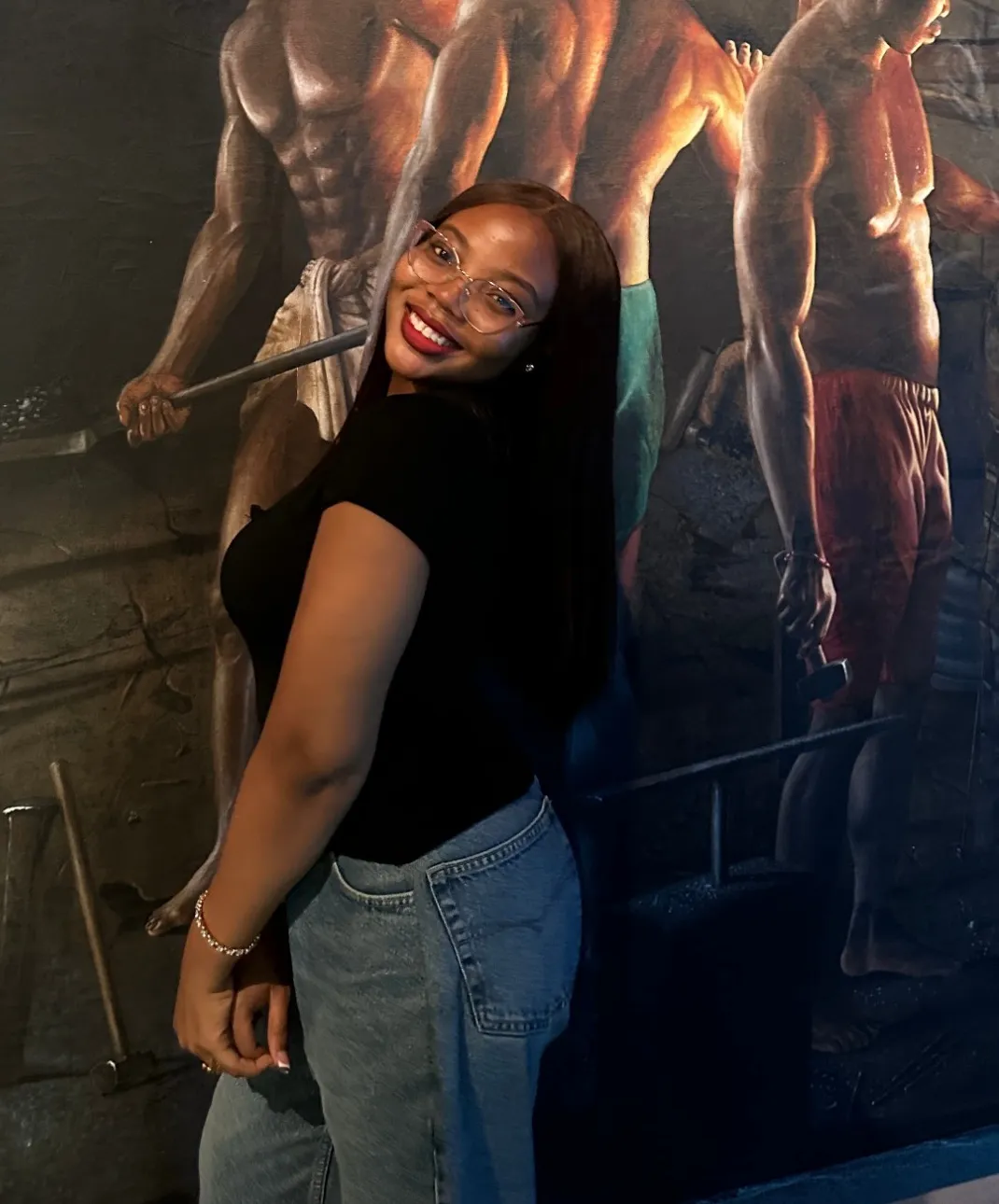 Faith smiling over her shoulder in front of a painted mural