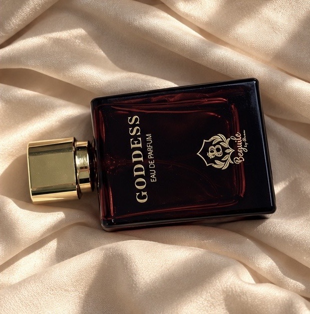 Goddess eau de parfum bottle lying on satin