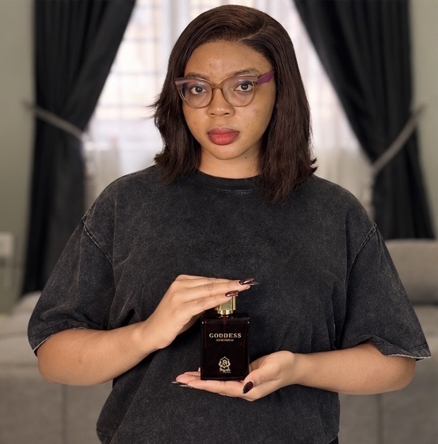 Faith holding Beguile by Omaa Goddess perfume